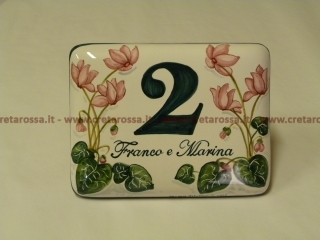 cod.art: nc11 - Mattonella in ceramica leggermente bombata cm 17x13 con ciclamini e scritta personalizzata. 